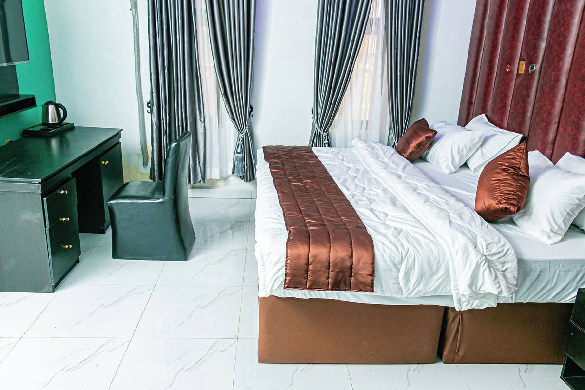 Ein Hotelzimmer mit Bett, Schreibtisch und Stuhl.