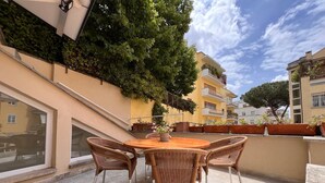 Une terrasse sur le toit, aménagée avec des meubles en osier et des plantes en pot.