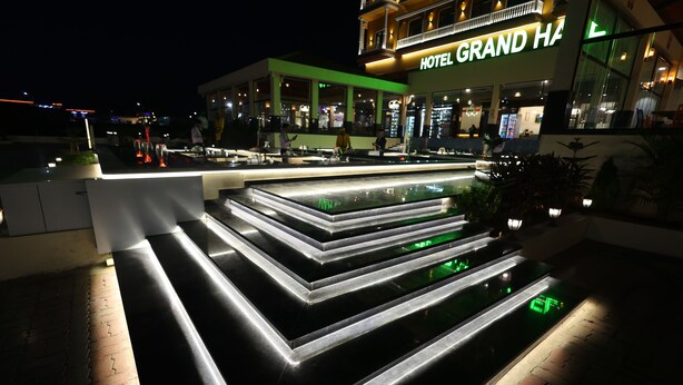 A modern hotel entrance with a well-lit staircase and a pool area. - HOTEL GRAND HAVELI (Umargam)