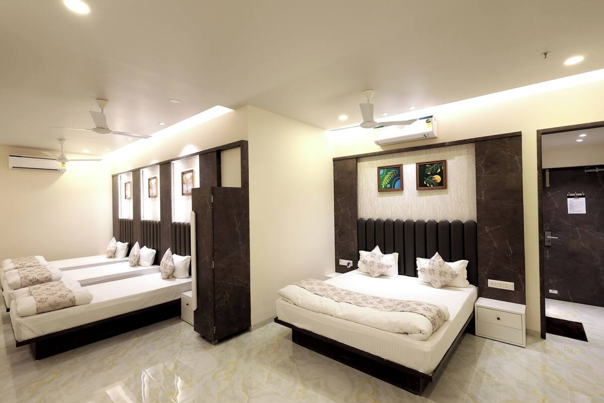 A modern hotel room with two beds, a large mirror, and a ceiling fan.