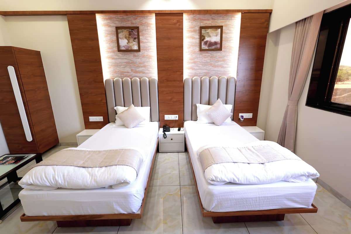 A double room with two beds, wooden headboards, a nightstand, and a small table.