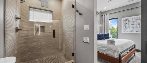 Une salle de bain moderne avec une douche à parois de verre, des toilettes et un lavabo.