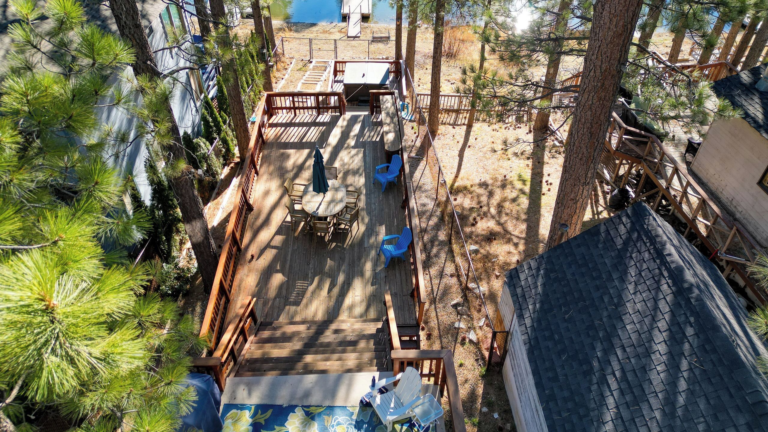 Une terrasse en bois avec des sièges extérieurs et une vue sur un lac.