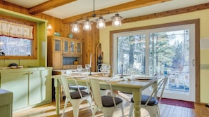 A dining area with a wooden table, chairs, and a view of the outdoors. - Lakefront w/ Private Dock, Hot Tub, Large Deck, Views Lakeside on Lagunita (Big Bear Lake)