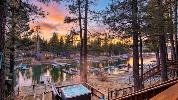 A lakeside property with a hot tub, docked boats, and a forested area. - Lakefront w/ Private Dock, Hot Tub, Large Deck, Views Lakeside on Lagunita (Big Bear Lake)