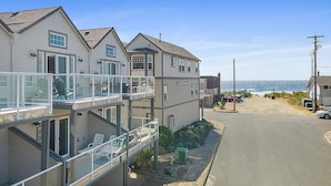 A coastal residential area with houses featuring balconies and a view of the ocean.