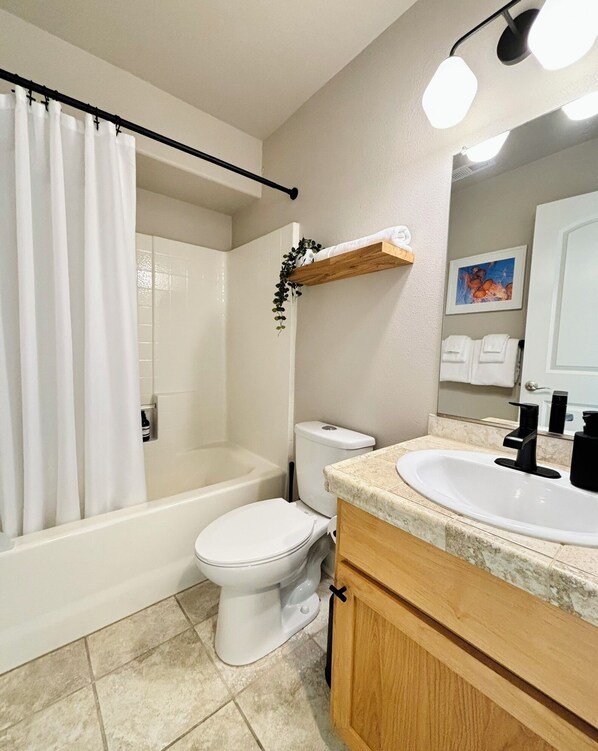 A bathroom with a bathtub, toilet, and sink.