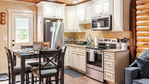 A kitchen with white cabinets, stainless steel appliances, a microwave, and a stove. - HOT TUB, outdoor movie theater, coffee bar,Fire pit, BBQ, pavilion & LAKE VIEWS! (Greentown)