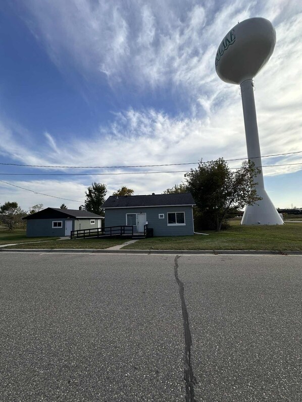 A house with a large white tower-like structure in front.