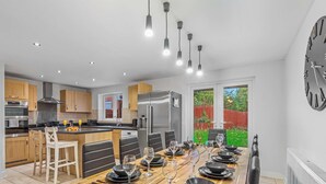 A modern kitchen with a dining area, stainless steel appliances, and a view of the backyard. - Whitley Rise, Reading (Berkshire)