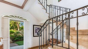 Un escalier orné de rampes en métal noir et dont l’intérieur est peint en blanc.