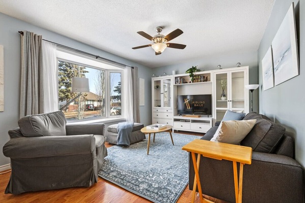 Living room features a large, north-facing window, Smart TV, plenty of books & cozy seating options to kick back on.