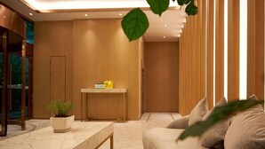 Un intérieur moderne avec une table en marbre, un canapé, une petite plante et un mur en bois.