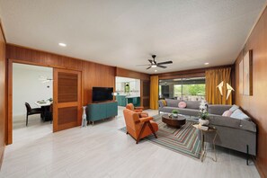 A modern living room with a sofa, armchairs, a TV, and a dining area. - Htd Pool Sleep12-Kng4BR+HotTub+Pklball+Bball+Arcde,SeaWrld,SixFlags,AirPt,DwnTwn (San Antonio)