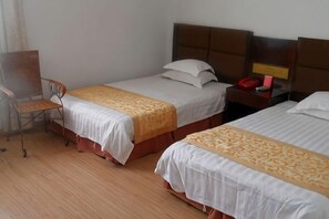 Una habitación de hotel con dos camas, un escritorio y una silla.