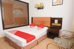 Una camera d'albergo con un letto, un comodino, una sedia e una finestra vista.