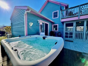Ein Haus mit Whirlpool, Terrasse und Balkon.