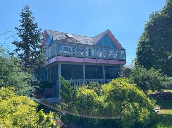Ein zweistöckiges Haus mit Balkon und überdachter Veranda.