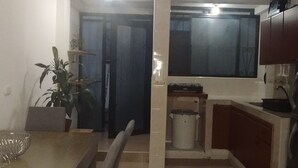 A compact kitchen with a dining area, featuring a tiled floor, a wooden dining table with chairs, a potted plant, and a built-in oven. - House in Santa Rosa de Cabal (Santa Rosa de Cabal)