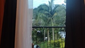 A balcony with a view of a palm tree and a parked car. - House in Santa Rosa de Cabal (Santa Rosa de Cabal)
