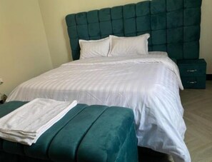 Relax in a spacious room with a large bed, tufted headboard, and matching bench.