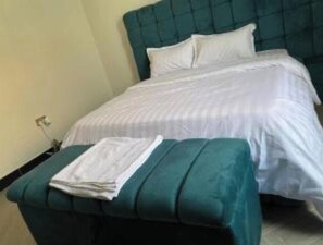 Relax in a cozy space with a single bed, green bench, and a simple design.