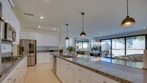 A modern kitchen with white cabinets, granite countertops, stainless steel appliances, and pendant lighting. - Luxurious & Spacious Family Duplex in Menifee! (Menifee)