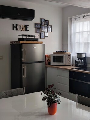 A compact kitchen with a refrigerator, microwave, and coffee maker.