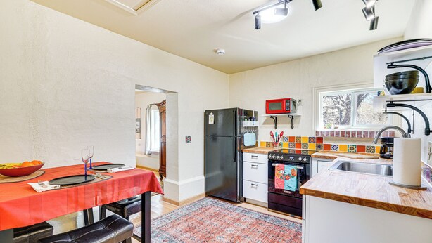 A compact kitchen with a dining area, a refrigerator, a microwave, and a sink. - Peaceful & Historic Home in Patagonia! (Patagonia)