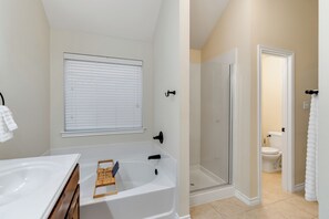 A bathroom with a bathtub, shower, and toilet. - Relaxing Burleson Retreat · Pool Table & Space&5TV/3BA (Burleson)