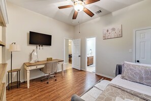 A bedroom with a bed, desk, chair, ceiling fan, TV, and artwork. - Relaxing Burleson Retreat · Pool Table & Space&5TV/3BA (Burleson)