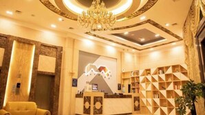 A hotel reception area with a modern design, including a chandelier, a reception desk, and a seating area. - Borrman Hotel Dongguan Zhongtang shop (Dongguan)