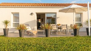 A house with a tiled roof, a patio with outdoor furniture, and potted plants. - House for 6 people with a quiet garden in Les Sables d'Olonne (Les Sables-d'Olonne)