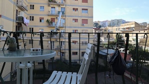 A balcony with a table, chairs, and a potted plant. - Milly's House (Naples)