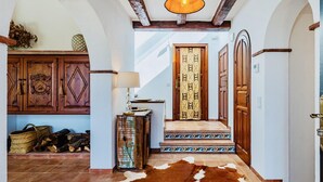 A hallway with a cowhide rug, wooden cabinets, and a patterned door. - Mas Nou CostaBravaSi - Pool, AC, nature, views (Platja d'Aro)