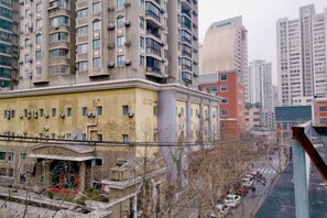 A high-rise building with multiple balconies and a yellow facade. - Red House Hotel (Shanghai Red House Hospital Lujiabang Road Subway Station Branch) (Shanghai)