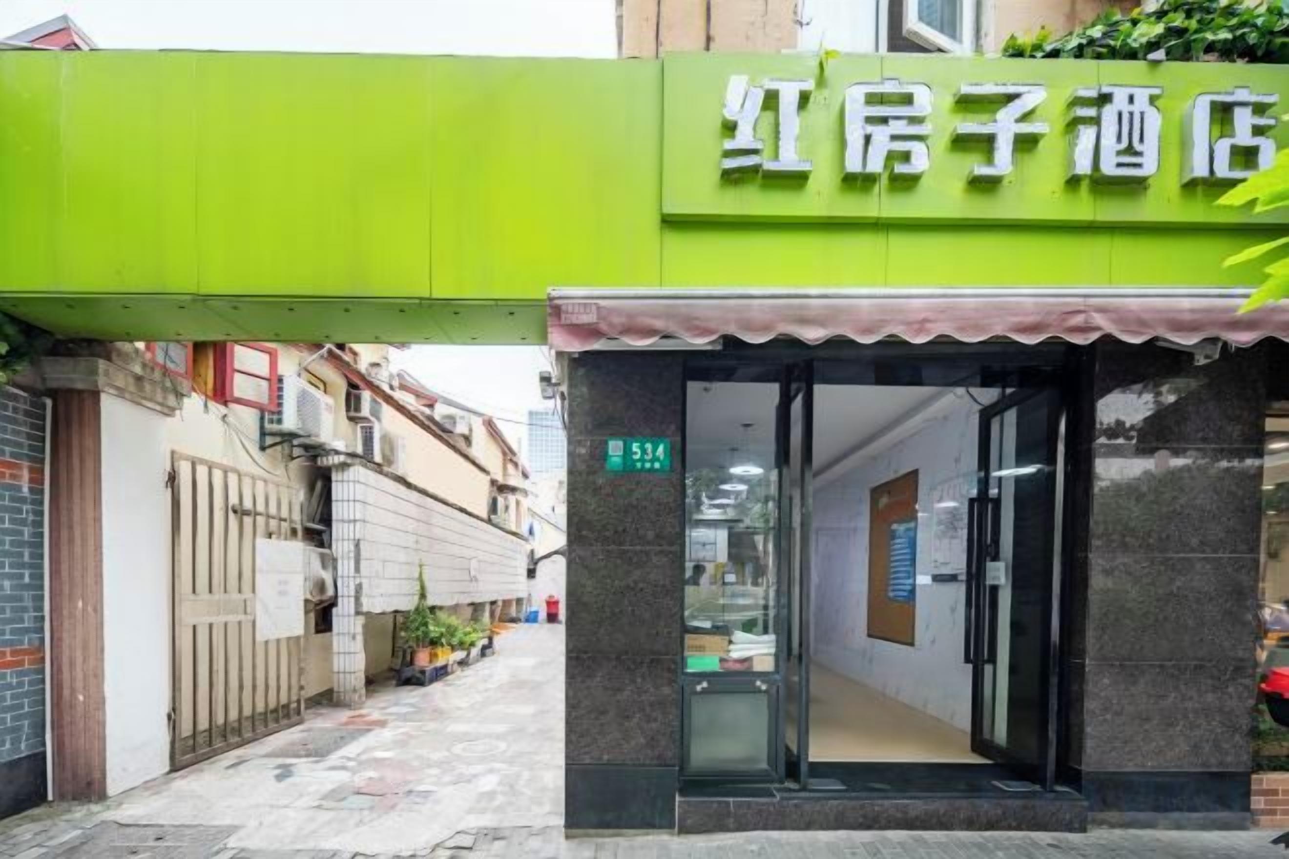 A hotel entrance with a green awning and a visible room number.