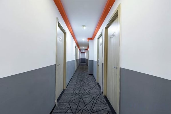 A hotel corridor with doors marked with room numbers, a patterned carpet, and orange ceiling accents. - Red House Hotel (Shanghai Red House Hospital Lujiabang Road Subway Station Branch) (Shanghai)