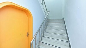 Una scala con ringhiere metalliche e una porta arancione brillante.