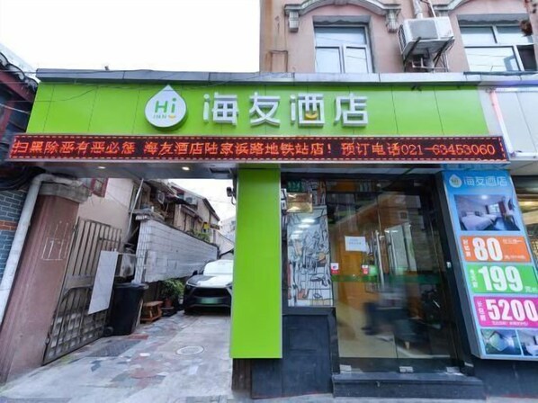 A hotel entrance with a green signboard, a visible entrance door, and a window displaying prices. - Red House Hotel (Shanghai Red House Hospital Lujiabang Road Subway Station Branch) (Shanghai)