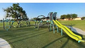 A playground with a yellow slide and climbing structures. - Affordable + Pet Friendly 1 BR + sofa bed/1BA #B (Lubbock)