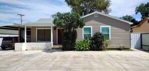 Une maison de plain-pied avec un garage, une véranda et une allée.