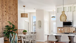 Ein modernes Wohnzimmer mit Essbereich, Küche und Blick ins Freie.