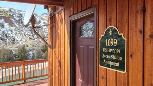 Una cabaña de madera con un letrero que dice "1099 US HWY 89 Queen Studio Apartment".