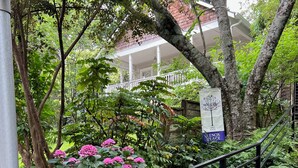 A garden pathway with a metal railing, surrounded by lush greenery and pink flowers. - Decatur Garden Studio Apartment (Decatur)