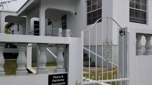 A gated entrance to an apartment complex with a sign reading 'Peace & Harmony Apartment.' - Charming One-Bedroom Apartment in Peaceful Telescope, St. Andrews, Grenada (Telescope)