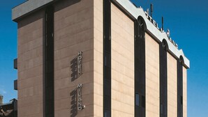 A modern hotel building with the name "HOTEL MILANO PADOVA" prominently displayed on the facade.
