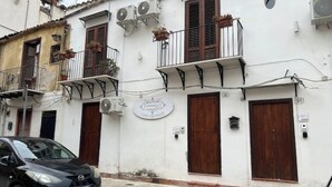 Un edificio con un letrero que dice "Dine's Casa Vacanze" y un coche negro estacionado en la parte delantera.