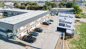 An Extended Stay by Welcome Inn with a parking lot and a building with multiple floors. - Extended Stay by Welcome INN (Blue Springs)