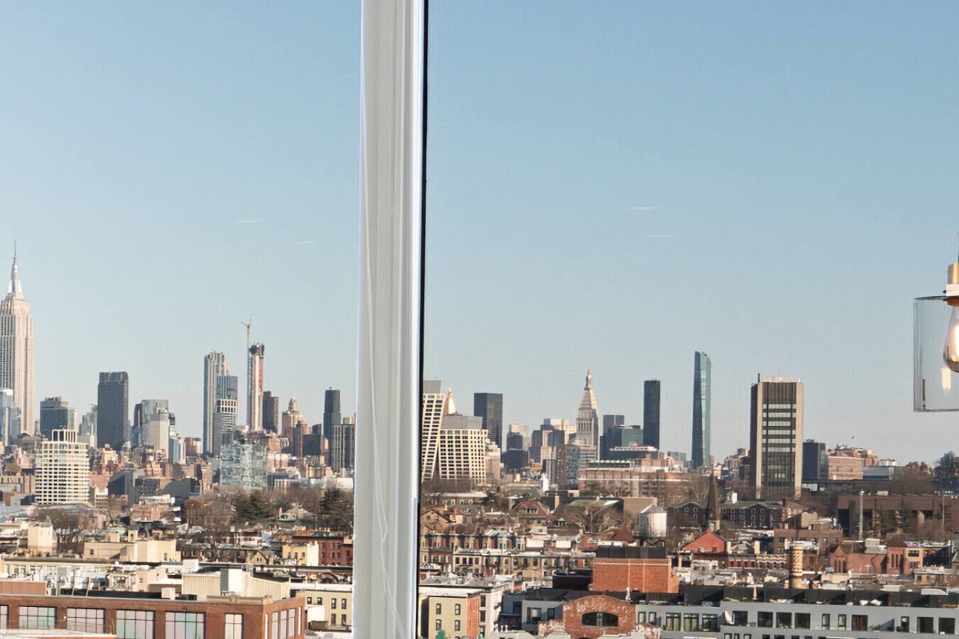Un horizonte urbano con edificios de distinta altura y estilos arquitectónicos, incluyendo un rascacielos destacado.
